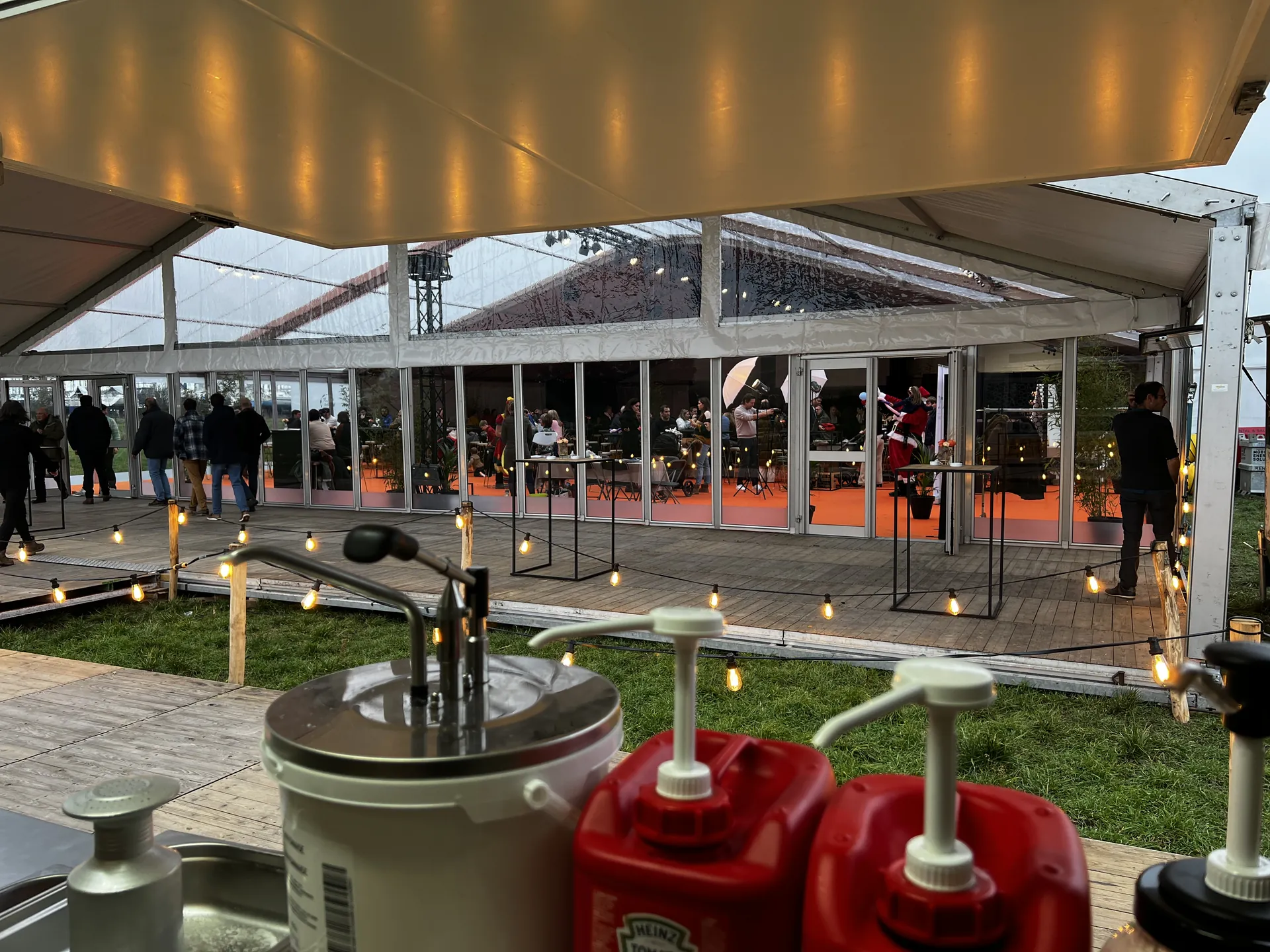 Zicht vanuit de foodtruck op een feesttent met lichtjes
