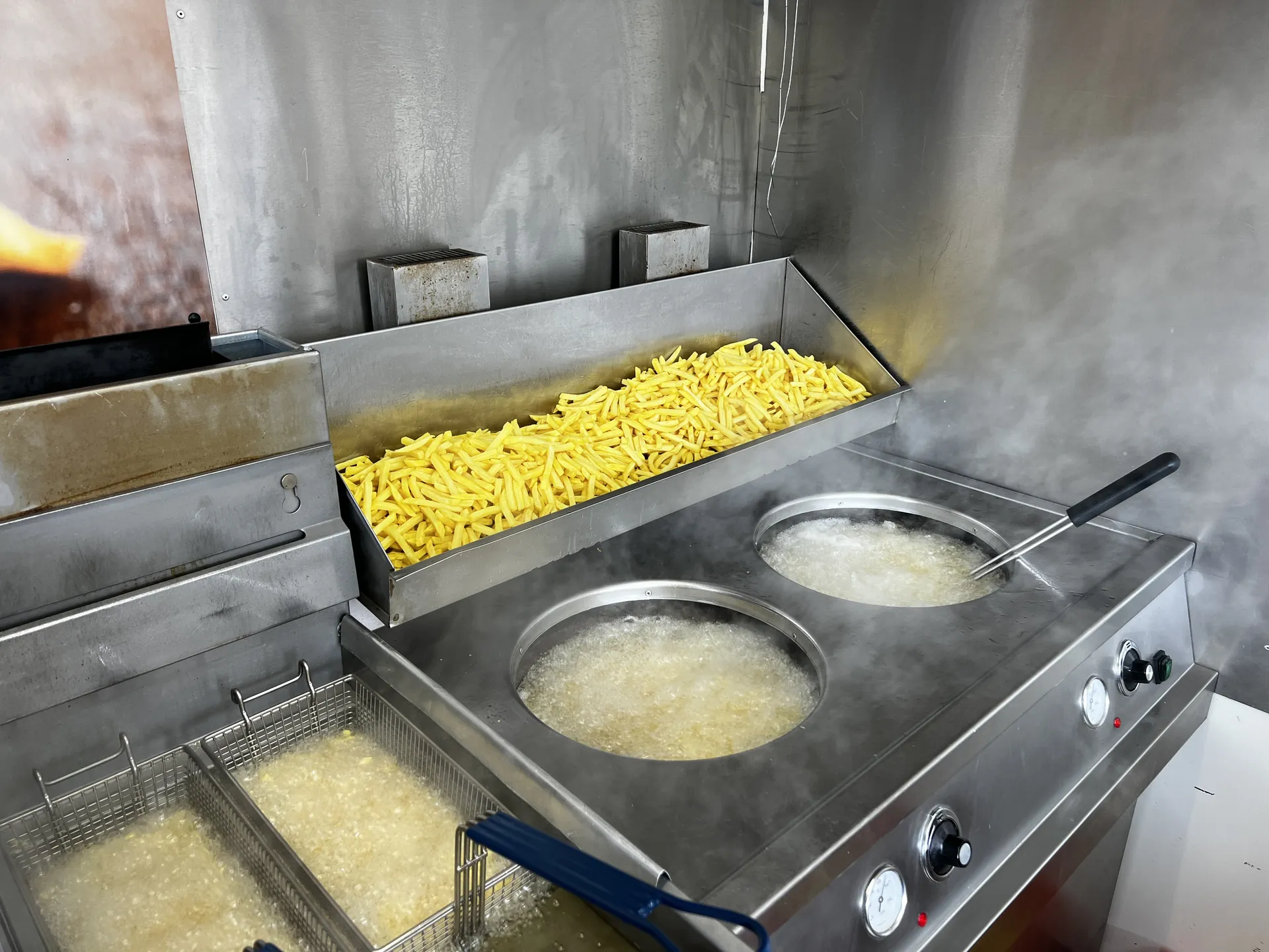 Verse frieten en dampende frietketels in de foodtruck